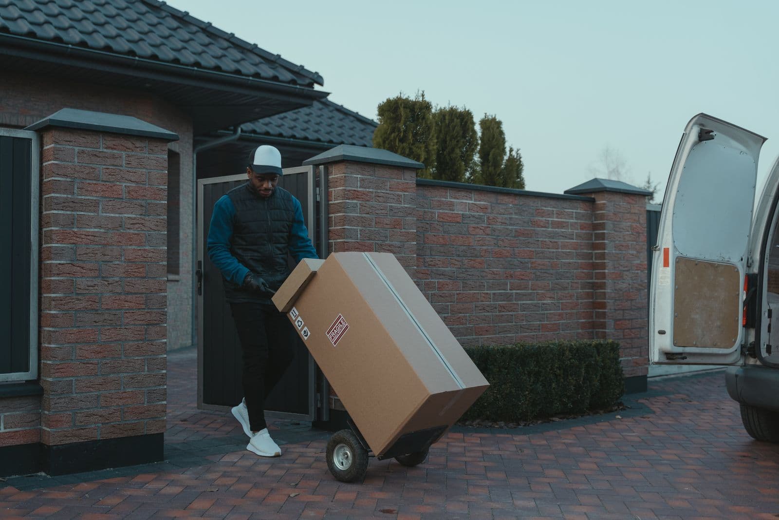 Mover using a heavy-duty hand truck to carefully transport a large, heavy item